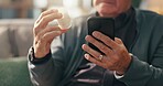 Hands, pills and phone on sofa with search for prescription, ingredients or label for side effects. Senior person, medicine bottle and smartphone on mobile app, online shopping or retirement in home