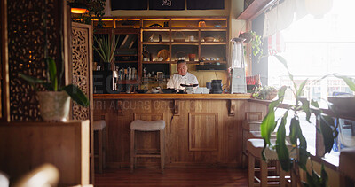 Buy stock photo Restaurant, food and sushi with Asian chef in kitchen for culinary service or hospitality. Concentration, menu and recipe with mature man preparing traditional cuisine or delicacy as business owner