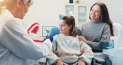 Buy stock photo Model, dentist and child with teeth for teaching, consultation or learning oral hygiene in office with mom. Mother, woman and girl in discussion at clinic with toothbrush for dental care education