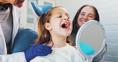 Buy stock photo Happy girl, mother and dentist with mirror for tooth implant, filler or veneers at clinic. Child, kid or open mouth with orthodontist or reflection for teeth checkup, surgery or oral and gum care