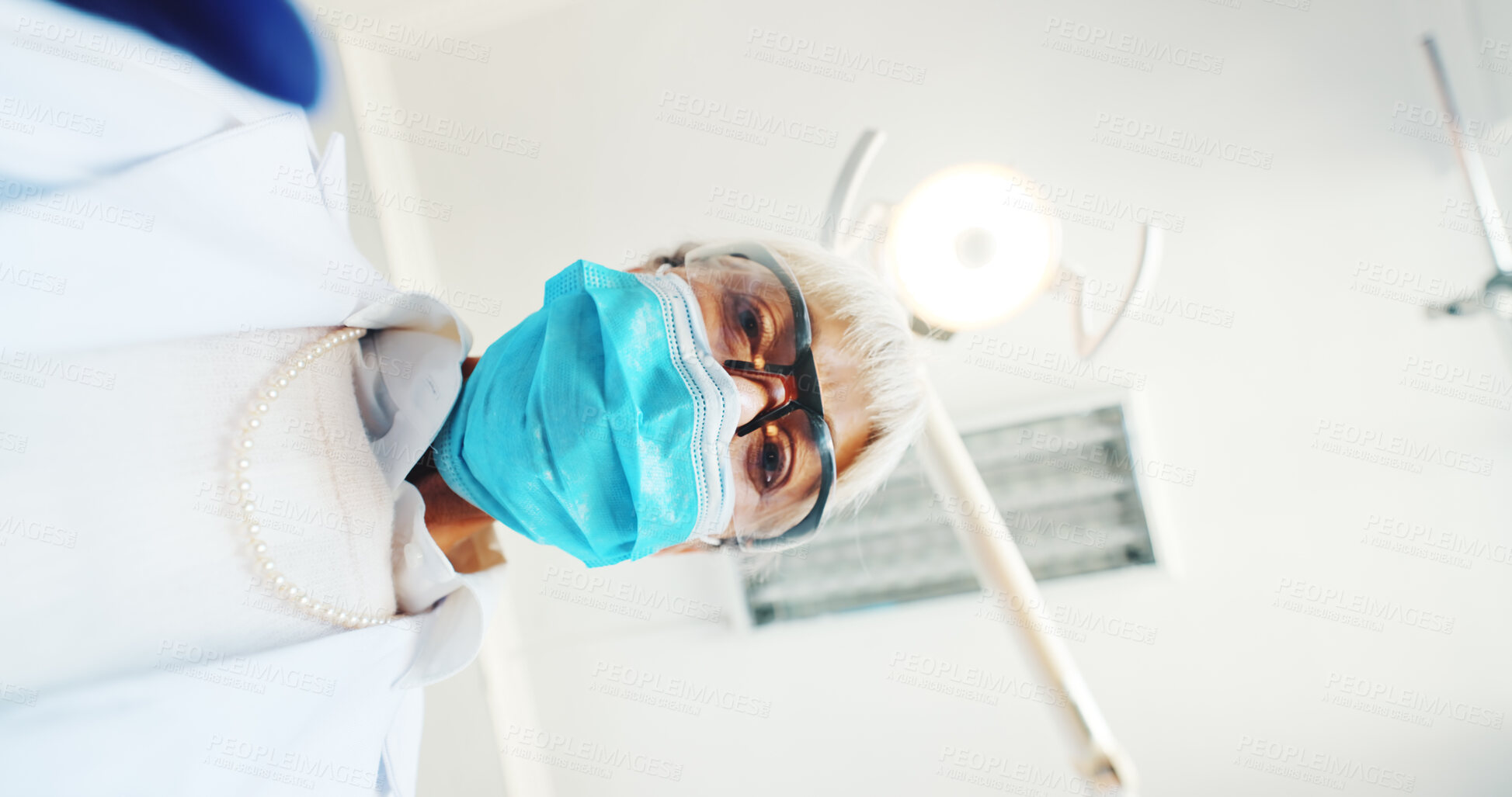 Buy stock photo Dentist, mask and low angle with pov for patient, oral assessment and ppe for surgery at hospital. Mature doctor, person and safety gear with light, exam and services for dental wellness at clinic