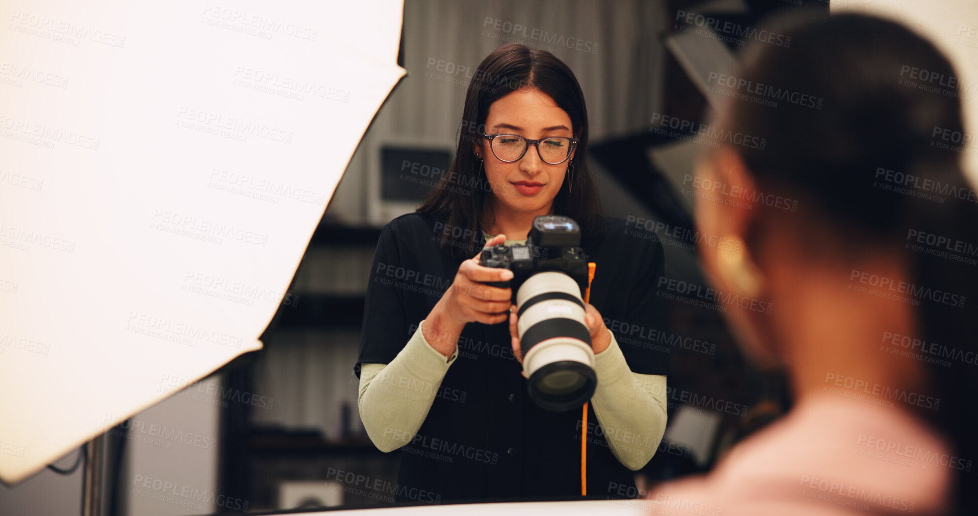 Buy stock photo Woman, photographer and check camera in studio of photoshoot results, catalog and review selection. Female person, equipment and backstage of lens focus, editing picture and filming production on set