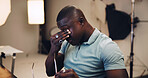 Frustrated, black man and headache with eye strain in production studio for overworked or stress. Male person, producer or director with migraine, pain or vertigo for burnout, fail or mistake on set