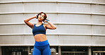 Headphones, fitness and woman in city with music, playlist or album for running, activity or training. Sports, exercise and female person listening to radio with audio tech for cardio workout in town