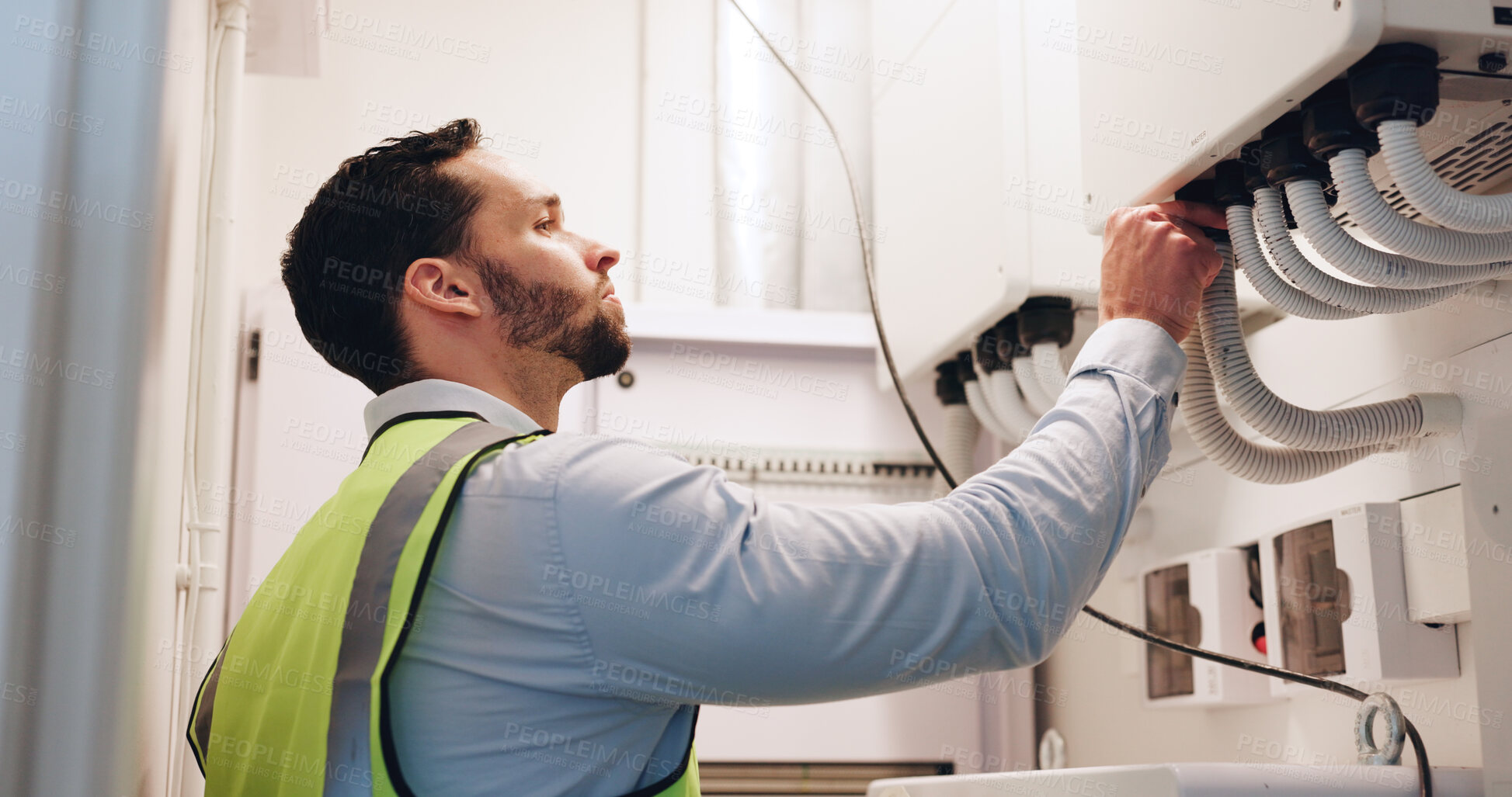 Buy stock photo Man, electrician and check fuse box at building for maintenance services, solution or tube for power. Person, engineer or technician with wires, profile and problem solving  at construction site