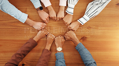 Buy stock photo Business people, above and fist on table with unity, collaboration and team building. Support, staff mission or group of employees with hands in office for synergy, meeting or solidarity together 