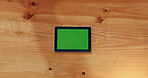 Above, tablet and green screen on table with connection, internet and website display. Technology, mockup space and online in business for connectivity, platform UI and UX for digital marketing