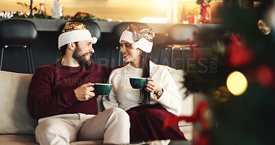Buy stock photo Christmas, happy and couple with coffee in home for festive morning with santa hat for celebration. Smile, love and man with woman on sofa for relax, bonding and drinking eggnog for xmas together.