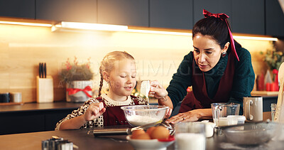 Buy stock photo Mom, girl and baking on Christmas with teaching, smile or measuring cup for festive cookies in home. People, mother and daughter in kitchen, happy or learning guide for xmas cooking in family house