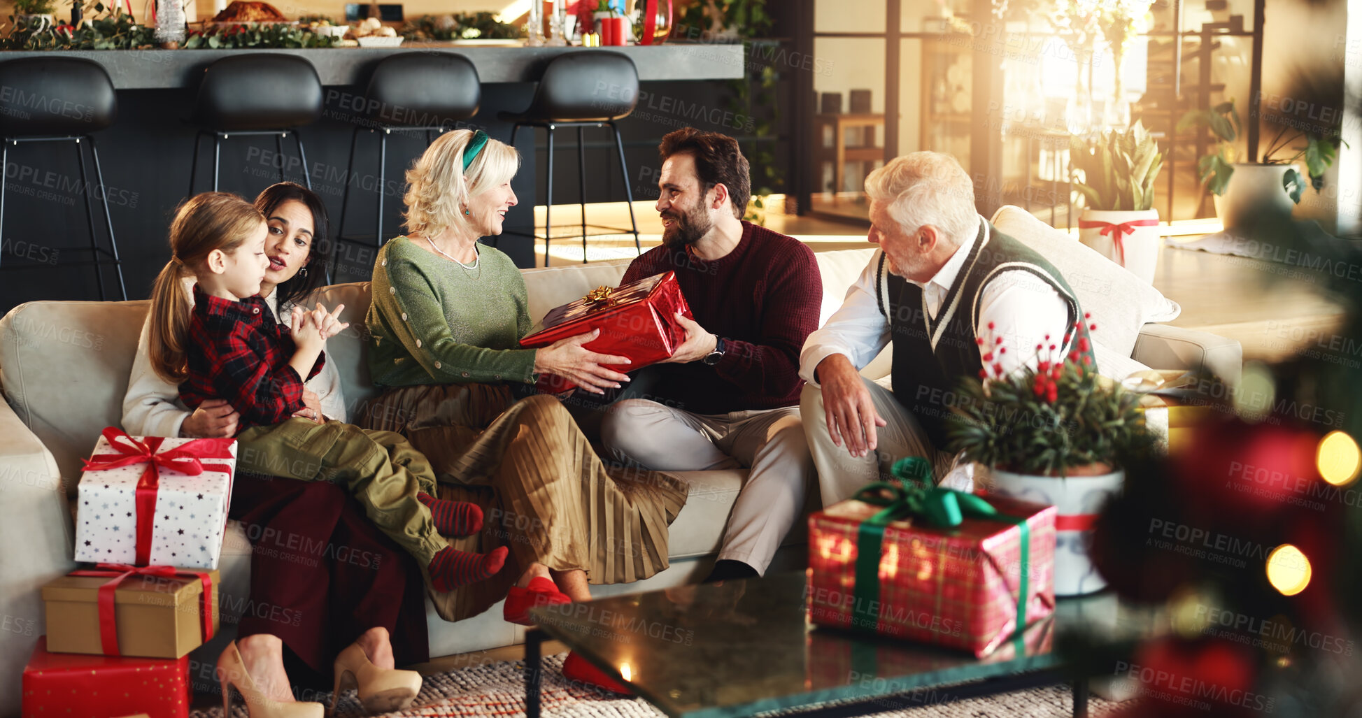 Buy stock photo Grandparents, parents and child with gift for Christmas, festive season and bonding on holiday. Happy family, home and girl with mom, dad and senior people for tradition, celebrate or giving presents