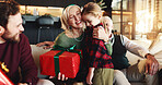 Christmas, gift and hug with grandmother and child on sofa for holiday season, bonding and support. Festive celebration, smile and present with family in living room of home for love and relax