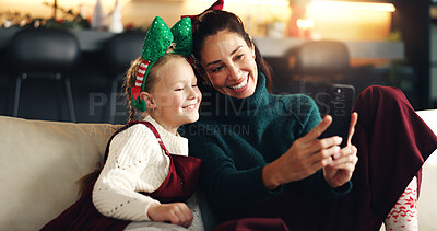 Buy stock photo Christmas selfie, mother and happy child with phone on sofa for festive season, bonding or family smile. Xmas, daughter and mom with tech in home for profile picture, social media or holiday memory