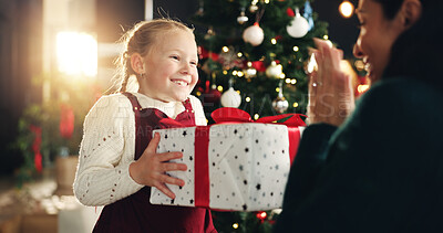 Buy stock photo Girl, excited and mom with gift, Christmas tree and thanks with love, bonding or festive holiday. Child, mother and daughter with box, package or smile for present at xmas celebration at family house