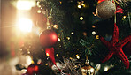 Celebration, Christmas and decoration with tree in living room of home for December holidays. Ball, bauble or ornament on branches in apartment for festive tradition or vacation in winter season