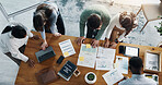 Documents, technology and tea of business people in office with planning for investment growth. Paperwork, discussion and group of financial advisors with statistics for profit report from above.