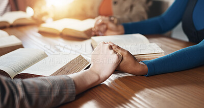 Buy stock photo Hand holding, Bible and people with prayer for religion, guidance or support with scripture for worship. Christianity, faith and group by table, book of God and praise with spiritual education