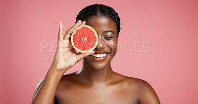 Buy stock photo Smile, black woman and grapefruit for skincare in studio for vitamin c, brighten skin and natural detox. Female person, fruit and organic benefits, beauty and dermatology results on pink background