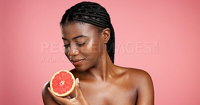 Buy stock photo Black woman, skincare and vitamin C with grapefruit in studio for health on a pink background. Female person, model and glow with natural organic fruit for detox, beauty or nutrition on mockup space
