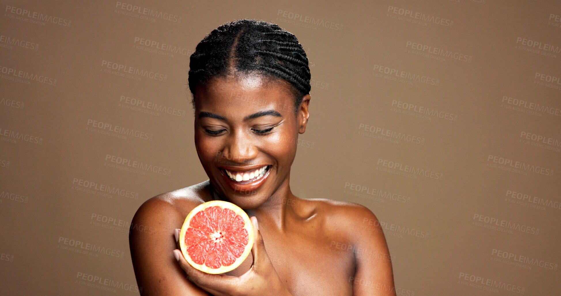Buy stock photo Beauty, happy and black woman with grapefruit in studio for natural, organic or facial glow routine. Dermatology, skincare and African person with citrus for face brightening by brown background.