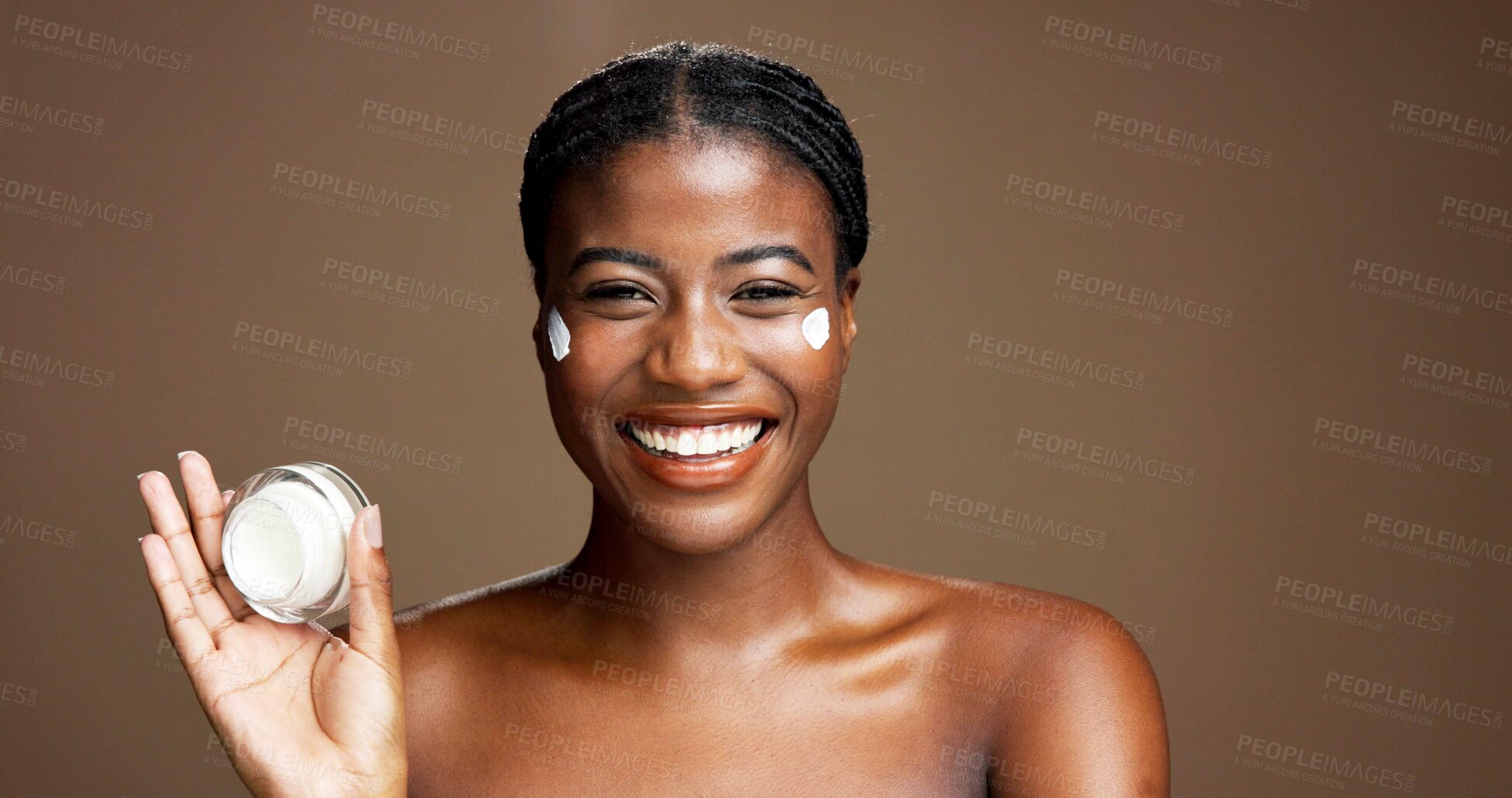 Buy stock photo Cream, skincare and smile with portrait of black woman in studio for beauty, cosmetics or dermatology. Glow, hyaluronic acid and self care with person and lotion on brown background space with jar