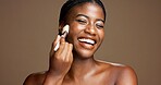 Makeup, brush and smile with black woman in studio for foundation application, glow and self care. Beauty tools, cosmetics and shine with female person on brown background space for blush powder