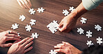 Puzzle, collaboration and hands of business people in office with synergy, teamwork or unity. Problem solving, planning and group of corporate employees with jigsaw for cooperation from above.