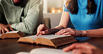 Bible study, hands and religion with people in home together for Christian belief, faith or prayer. Book, reading and spirituality with group of friends in apartment for learning or God worship