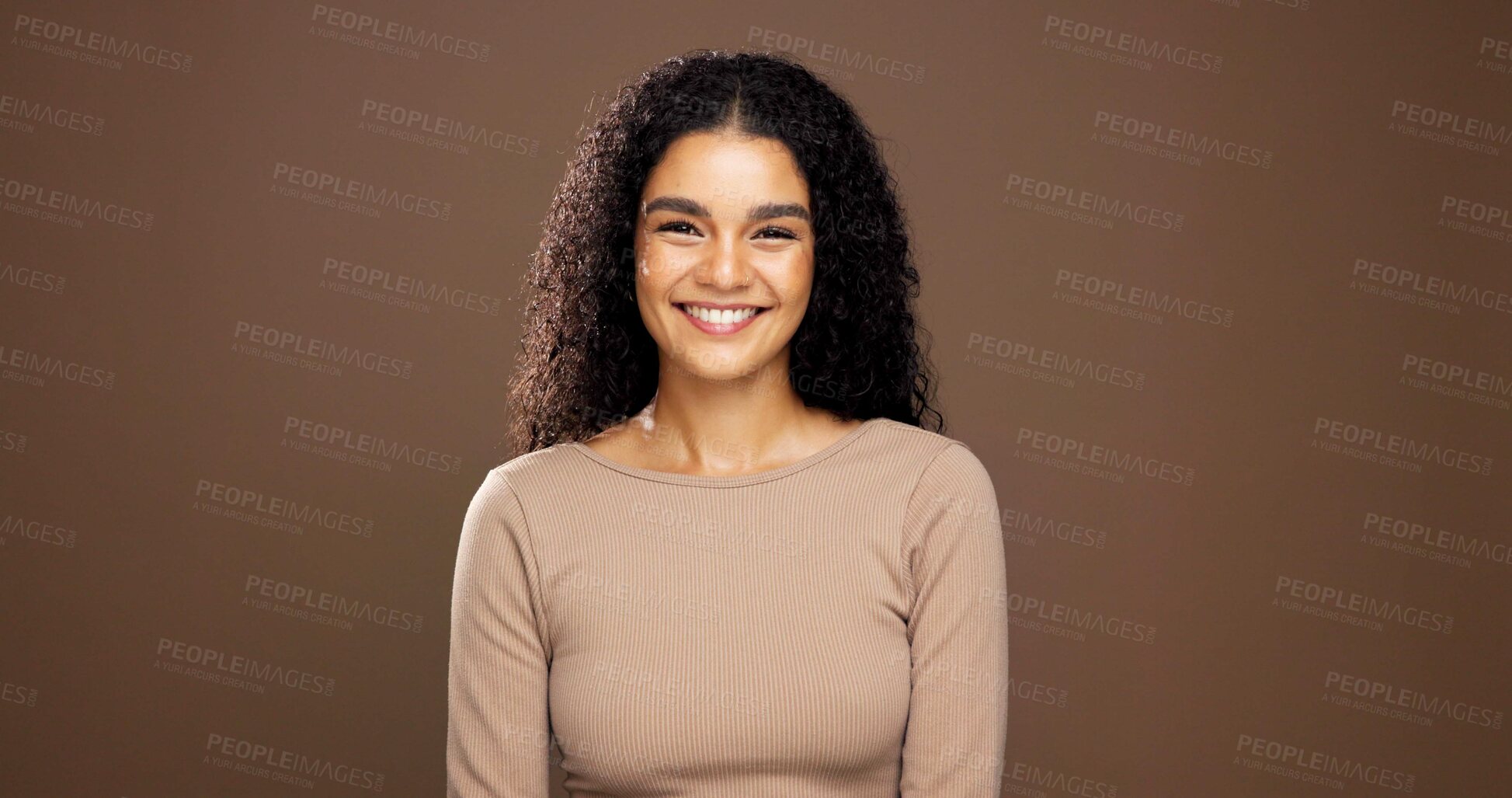 Buy stock photo Natural, happy and portrait of woman in studio for beauty, curly hairstyle and healthy texture. Hair care, mockup space and person with shine for treatment, growth and cosmetics on brown background