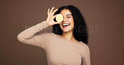 Buy stock photo Portrait, woman and lemon for skincare in studio for vitamin c, brighten skin and natural detox. Female person, citrus and fruit for organic benefits, beauty and exfoliate results on brown background