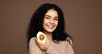Beauty, girl and portrait with avocado in studio for natural skincare, vitamin c or skin elasticity. Mockup space, woman and happy with fruit on brown background for collagen treatment and hydration