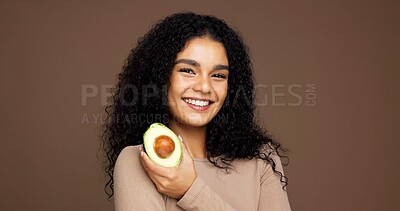 Buy stock photo Beauty, girl and portrait with avocado in studio for natural skincare, vitamin c or skin elasticity. Mockup space, woman and happy with fruit on brown background for collagen treatment and hydration