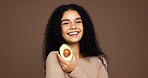 Beauty, woman and portrait with avocado in studio for skincare glow, vitamin c or skin elasticity. Mockup space, person and happy with fruit on brown background for natural antioxidants and hydration