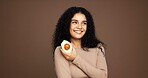 Beauty, girl and happy with avocado in studio for natural skincare, vitamin c or skin hydration. Mockup space, woman and confidence with fruit on brown background for anti aging benefits and collagen