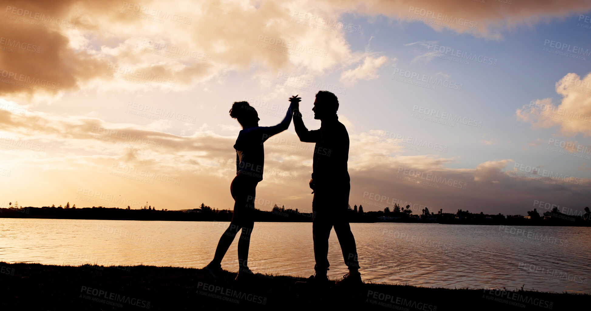 Buy stock photo Fitness, sunset and couple in nature with high five for running, workout or goal achievement. Celebration, athletes and silhouette of man with woman for cardio exercise or training outdoor by lake.