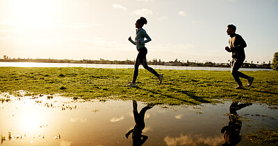 Buy stock photo Fitness, running and sunset with couple outdoor at lake in nature for cardio training on space. Exercise, field and reflection with people on grass in park together for health, wellness or workout