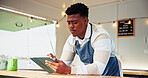 Black man, owner and reading on tablet at food truck for online order, inventory update and event planning. Male person digital and review price list, menu checklist and vendor application of startup