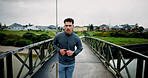 Running, bridge and man in city for fitness, marathon training and workout for challenge. Sports, runner and person for wellness, performance and health in winter for endurance, cardio and exercise