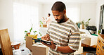 Tablet, moving and hands of man in new home for research on renovations, interior design or online shopping. Digital technology, cardboard boxes and male person on app for ecommerce purchase in house