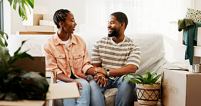 Buy stock photo Moving in, couple or holding hands on sofa in new home for conversation, mortgage security or goals. Real estate, black people and happy with discussion in house for relocation support or achievement