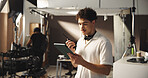 Man, filming and radio with tablet on set for discussion, reading script and shooting schedule. Director, backstage and digital with crew advice, scene tips and performance guide for movie production