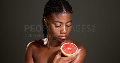 Buy stock photo Black woman, grapefruit or beauty with skincare in studio for skin detox on a dark background. Female person, model and natural organic fruit for antioxidant, vitamin C or body health on mockup space
