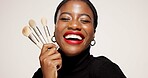 Studio, happy and woman with makeup brush, confident or equipment for beauty, makeover and selfcare. White background, black person and cosmetic for self expression, creative and tools for foundation
