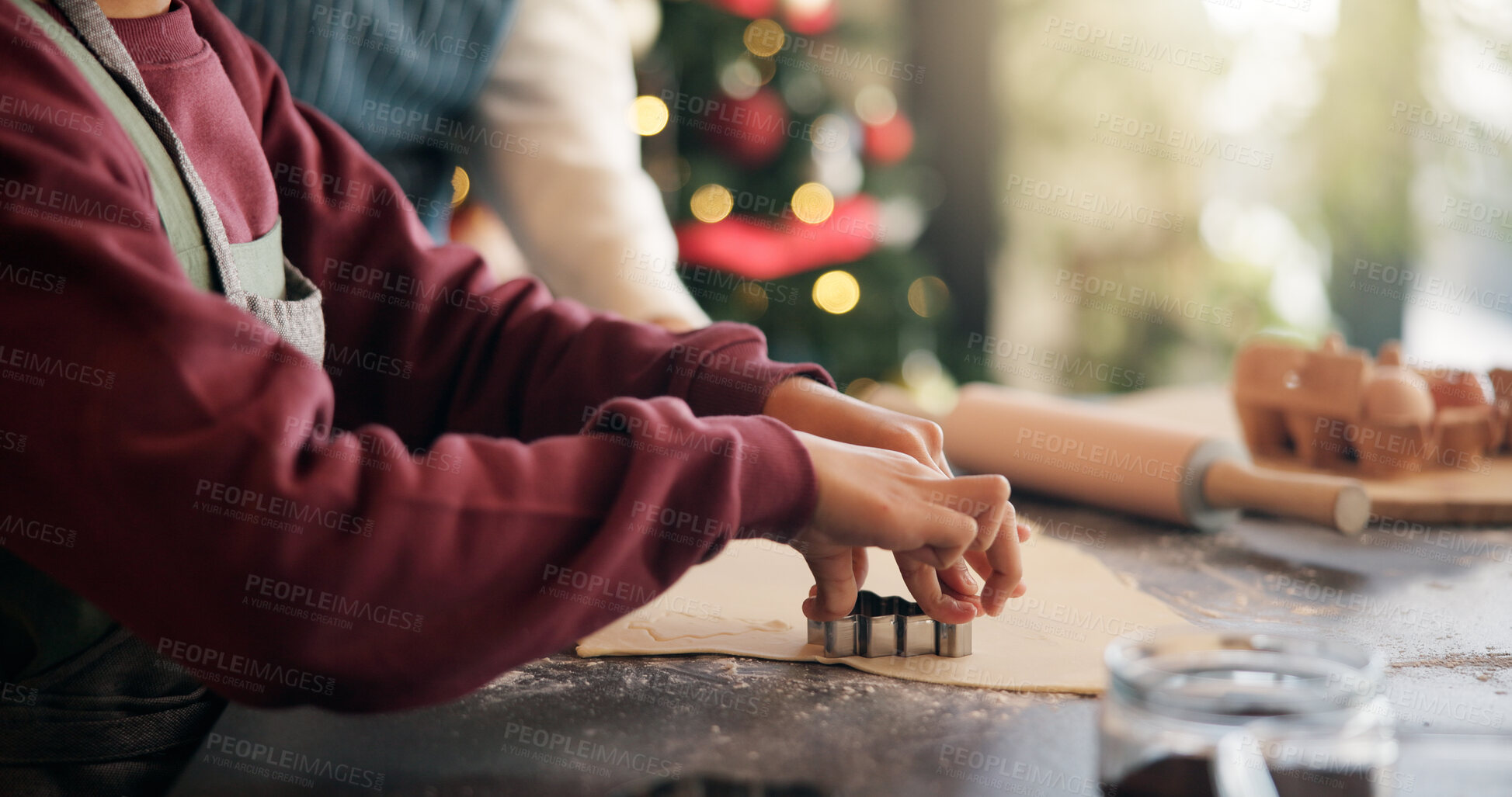 Buy stock photo Christmas, cookie cutter and hands of child with parent in kitchen of home for festive tradition. Baking, help and holidays with family at apartment together for cooking or learning in December