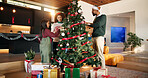 Parents, kid and christmas tree decoration in home for holiday tradition, celebration or bonding. Help, african people and bauble ornaments in lounge for xmas aesthetic, event preparation and support