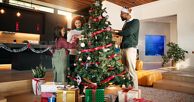 Buy stock photo Parents, kid and Christmas tree decoration in home for holiday tradition, celebration or bonding. Help, African people and bauble ornaments in lounge for xmas aesthetic, event preparation and support
