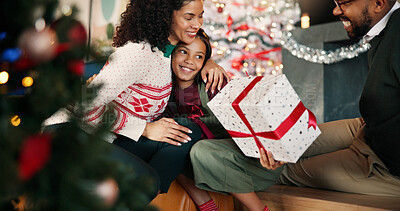 Buy stock photo Christmas, family and hug child with gift for thank you, gratitude or celebration. Present, mom and dad embrace kid for love, care or appreciation with happy African parents in home for xmas holiday