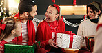 Christmas, home and family in lounge, present and excited with smile, bonding together and festive. Group, apartment and Xmas with people, gifts and giving with happiness, holiday season or tradition