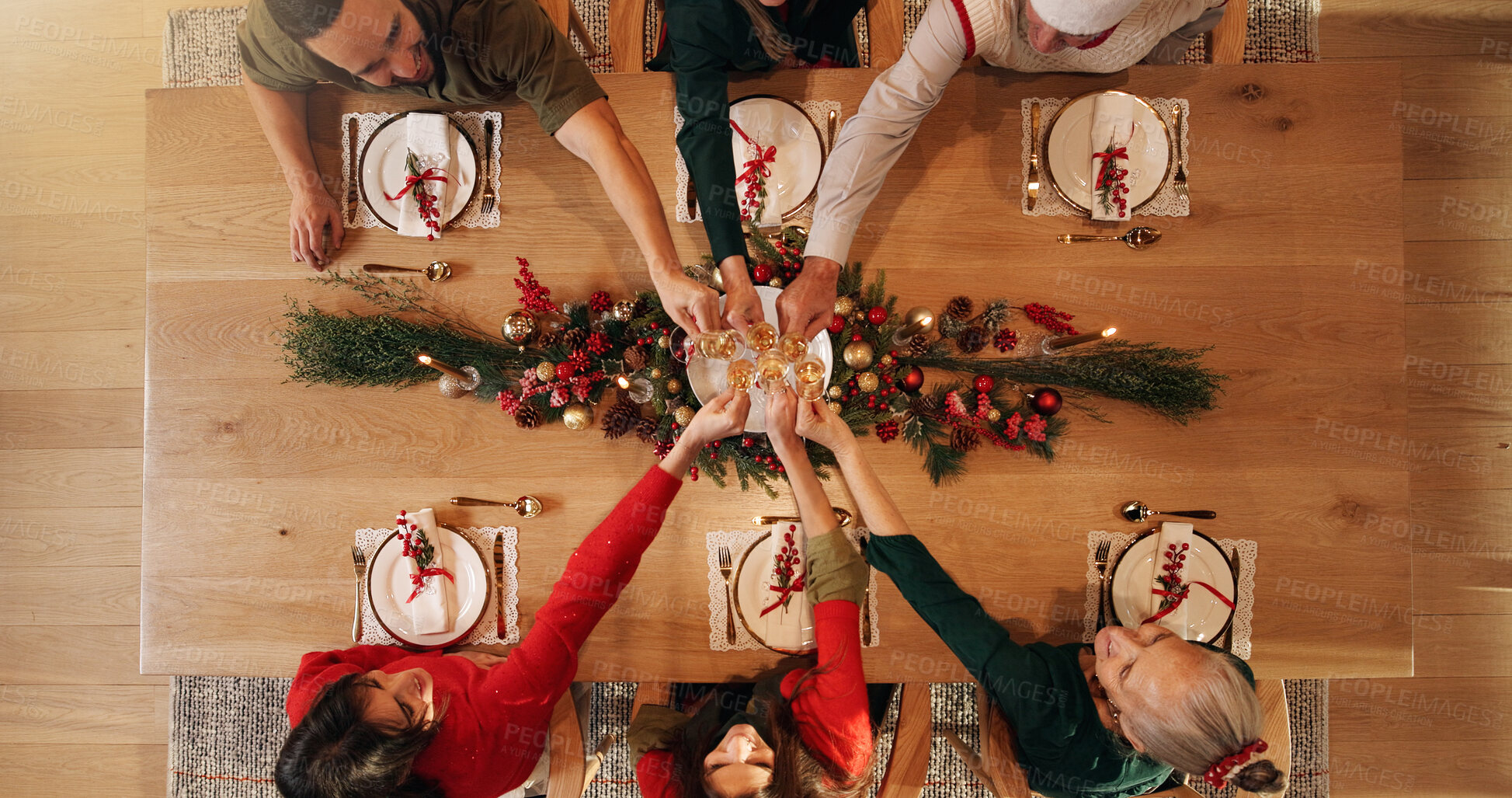 Buy stock photo Cheers, champagne and family in home for Christmas, celebration or event in dining room. Toast, festive season and group of people with sparkling wine for xmas party with bonding in house from above.