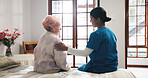 Comforting, talking and nurse with senior woman in bedroom for support, help and care in nursing home. Retirement, healthcare and caregiver with old person for empathy, conversation and consulting