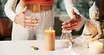 Hands, home and woman with candle, holistic and atmosphere with religion, traditions and prayer. Closeup, apartment and person with buddha statue, ambience and aromatherapy with healing and wellness